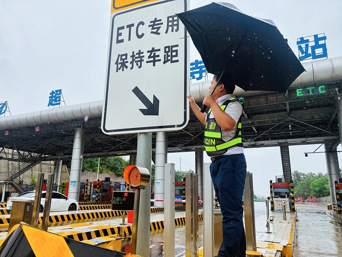 4、郑州分公司超化寺主副站值班班长冒雨检查ETC车道标识标牌稳固情况.jpg