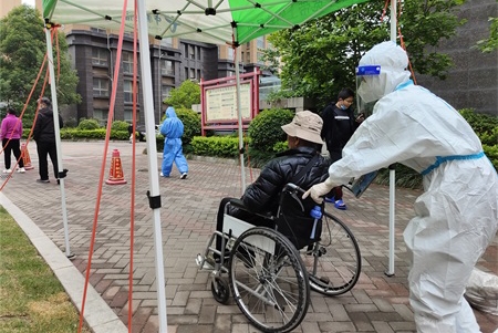 图3：“秩序大白”帮助行动不便老人参加社区核酸检测。王小东摄.jpg